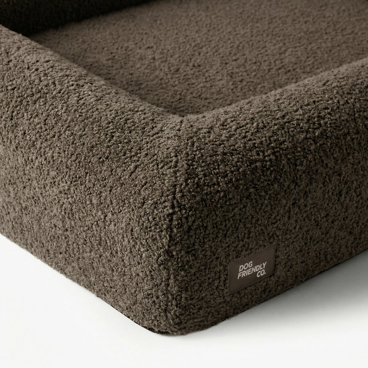 Close-up of the Brown Bouclé orthopedic dog bed showing its soft textured cover, raised sides and reinforced stitching.