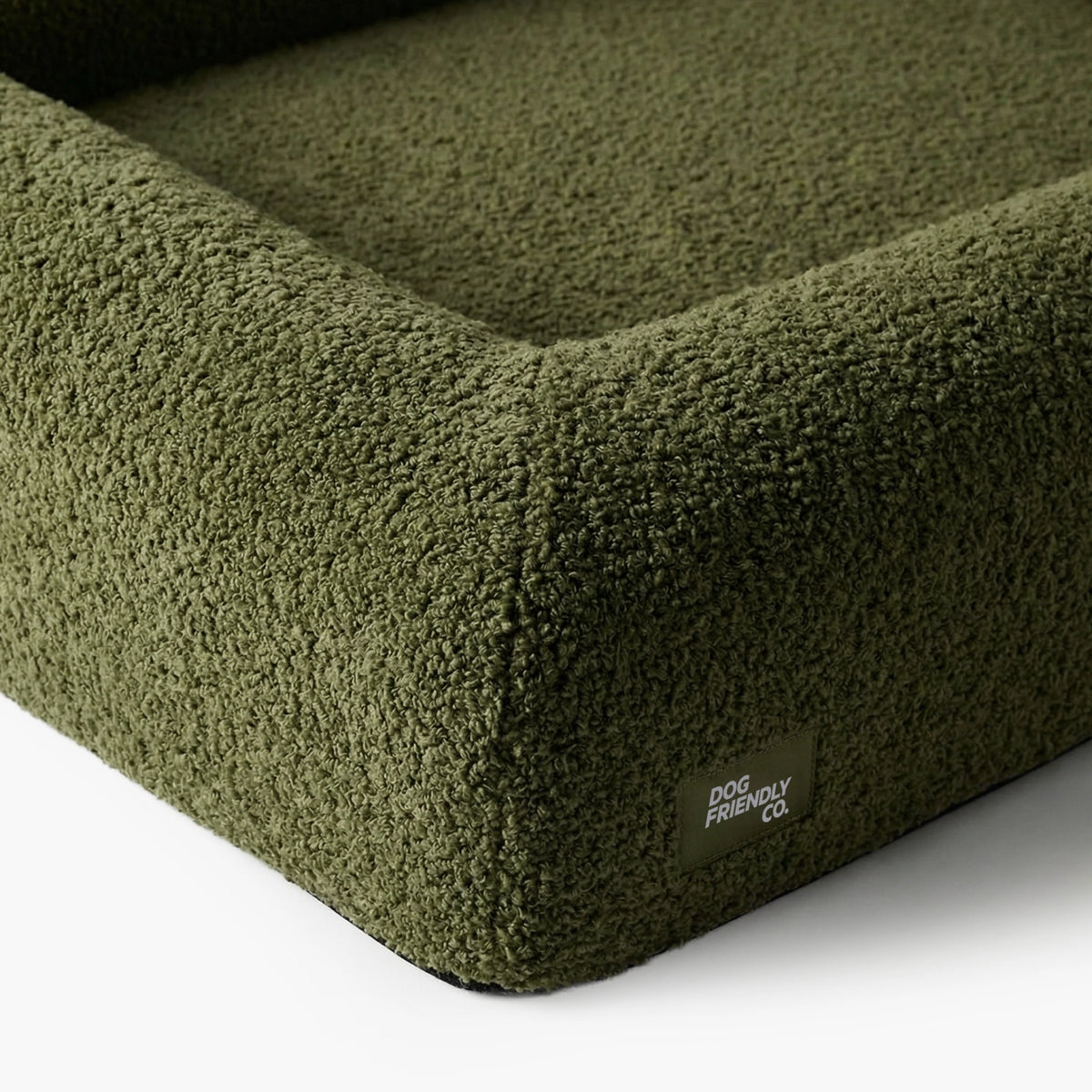 Close-up of the Green Bouclé dog bed showing the soft textured cover and raised supportive sides.
